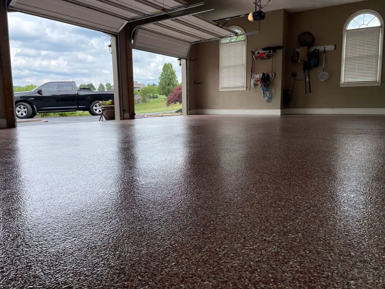 Residential two-car garage with flake epoxy floor and a pickup truck visible at the open door