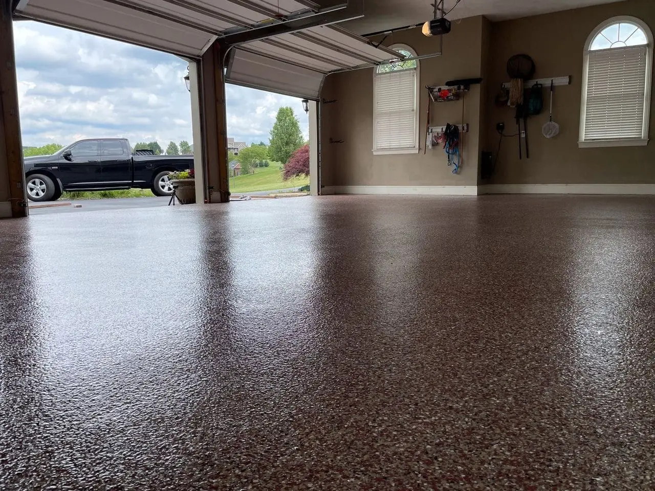 Residential two-car garage with flake epoxy floor and a pickup truck visible at the open door