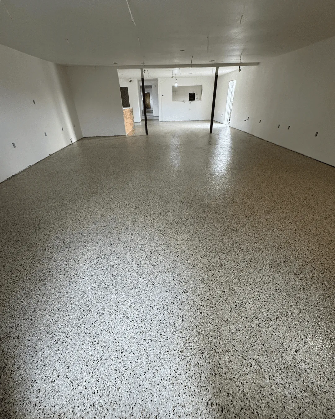 Large open commercial floor with neutral flake epoxy installed by Pure Reflection
