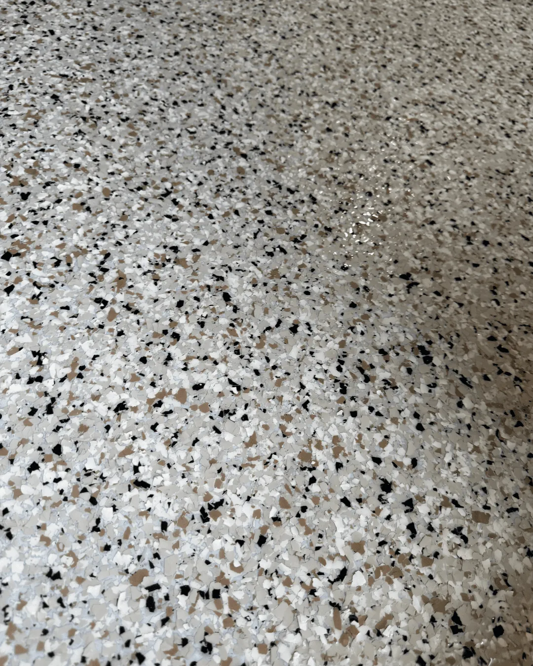 Close-up of multi-color flake epoxy floor with copper, black, and white chips